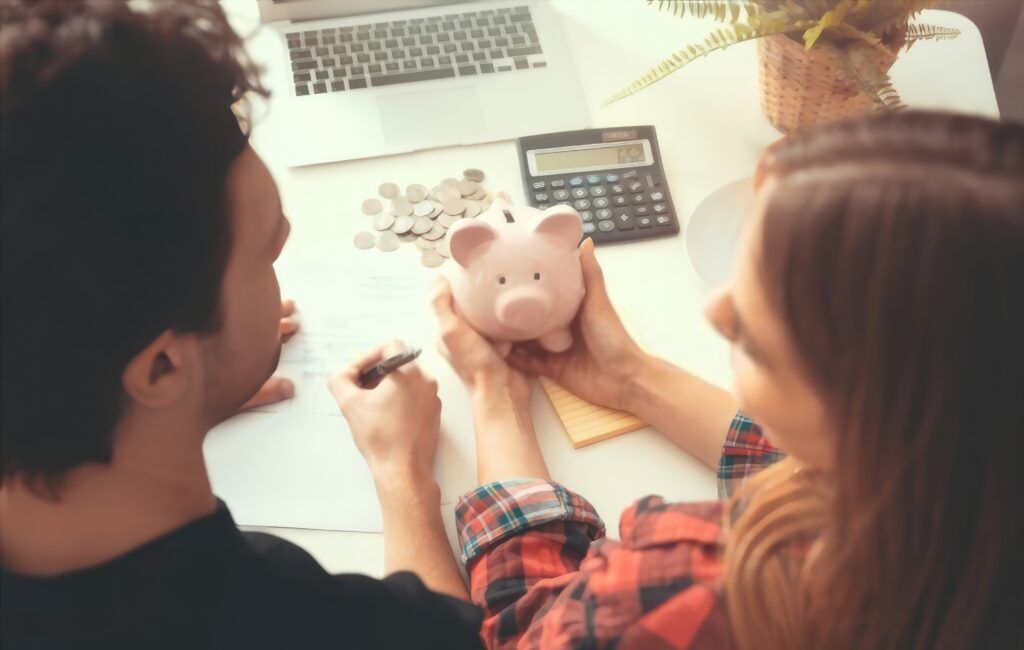 Dos manos entrelazadas sosteniendo monedas y billetes, simbolizando la unión y colaboración en parejas y finanzas para lograr el éxito financiero.